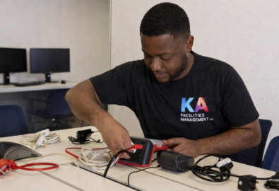 PAT testing engineer carrying out electrical equipment inspection in a Glasgow office